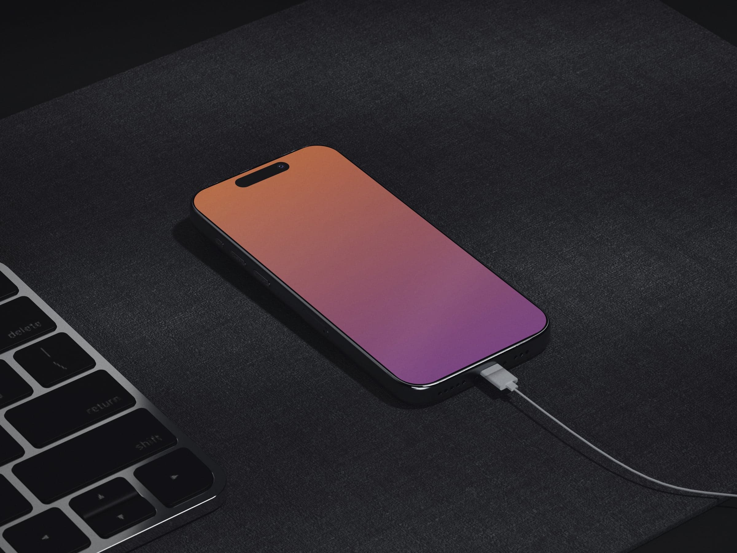 NOIR 08 iPhone charging beside a keyboard on a dark mat mockup preview